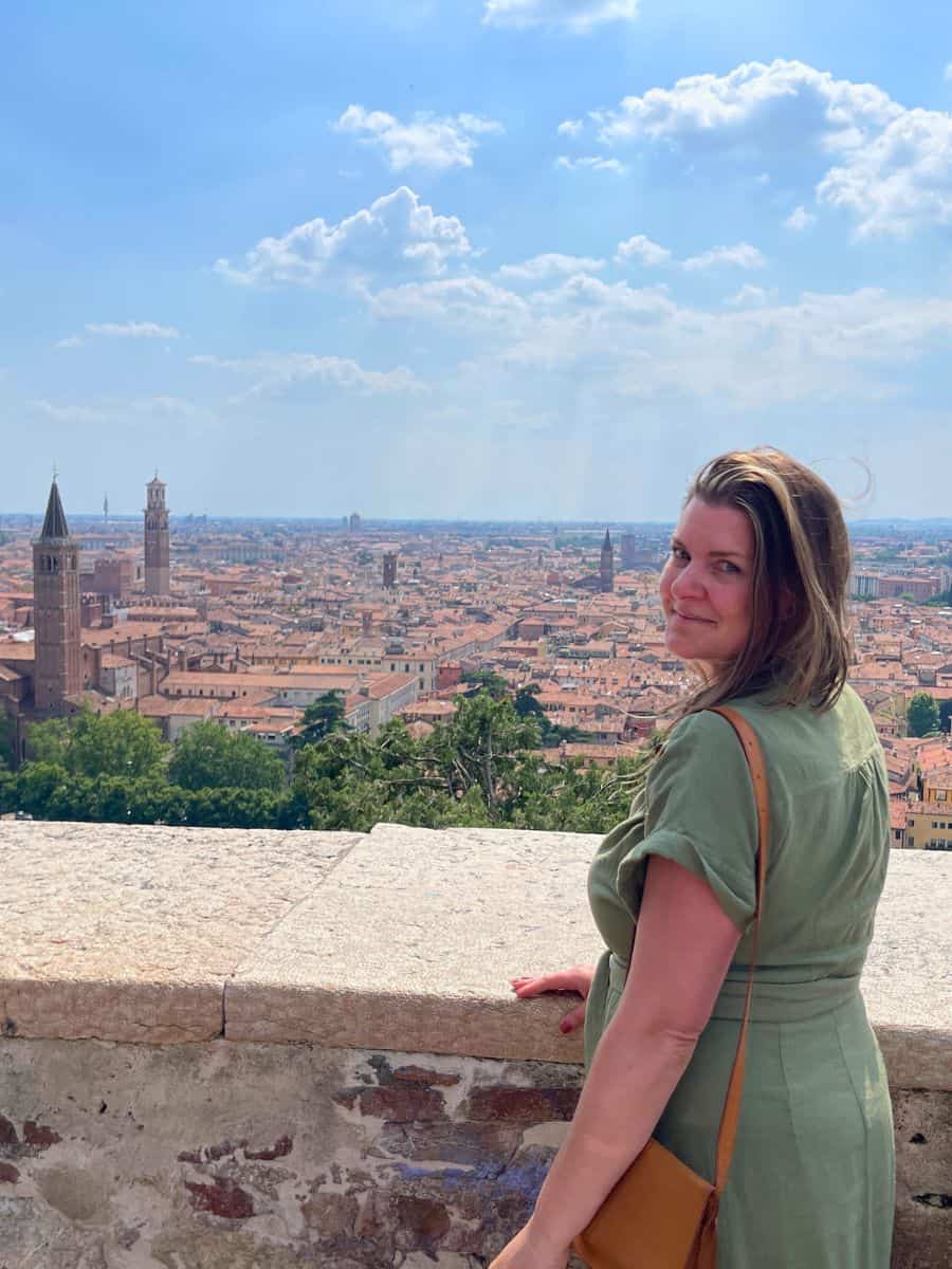 A Solo Woman Traveling in Verona Italy standing at a ledge with the city in the background
