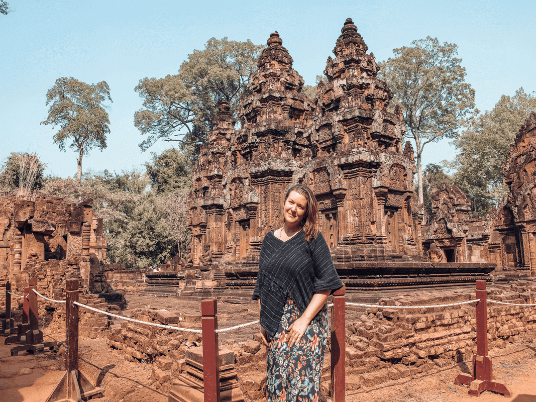 7 Reasons Why Solo Travel Is Better After 35, a woman stands in front of old stone ruins.
