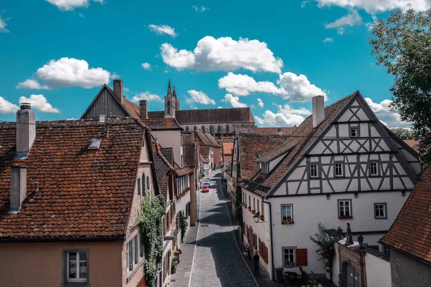 A picturesque view down a cobblestone street lined with traditional German houses in Rothenburg ob der Tauber
