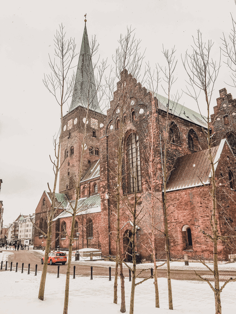 Perfect Copenhagen to Aarhus Itinerary, an old stone cathedral on a snowy day.