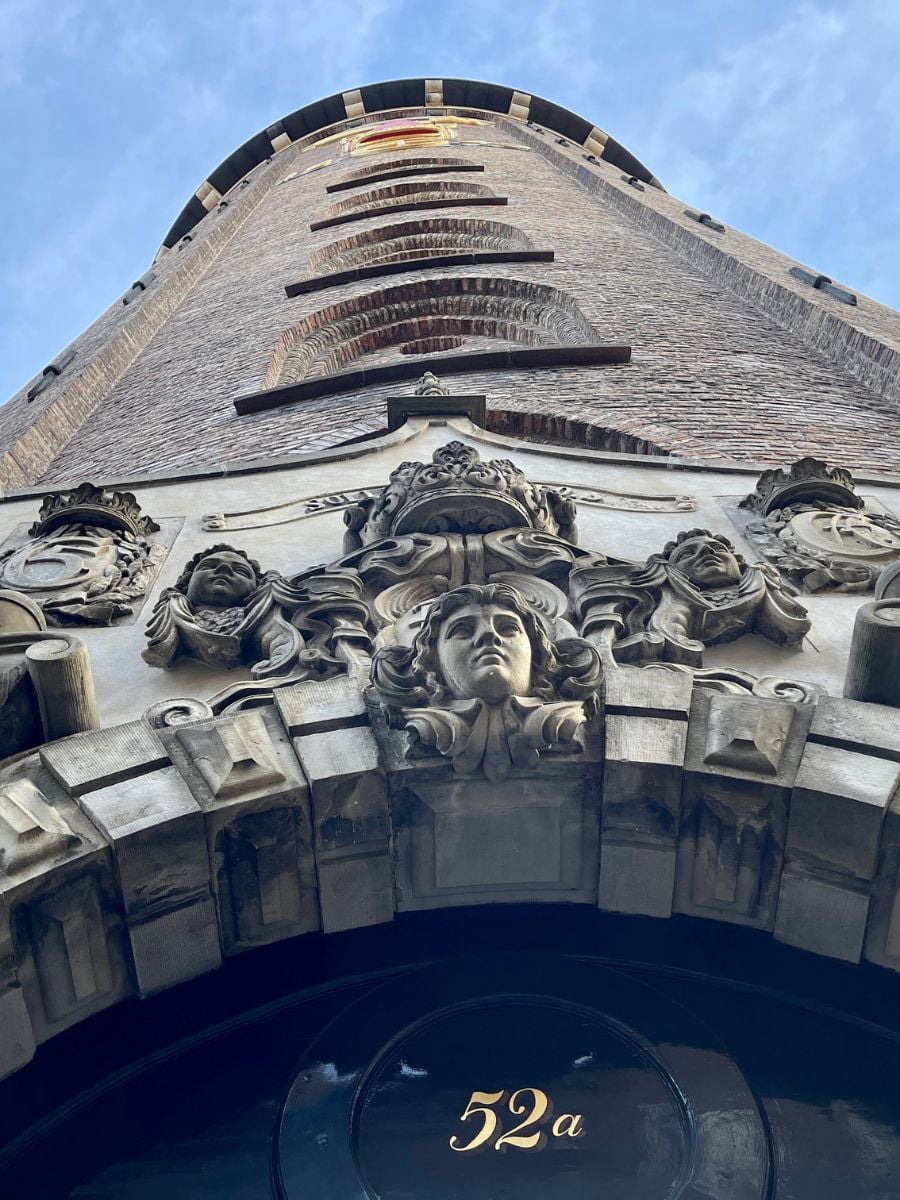 Upward view of the Round Tower entrance in Copenhagen showing ornate stone carvings and brick architecture.