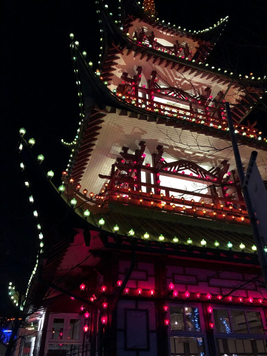 Tivoli Gardens illuminated at night in Copenhagen with colorful lights and historic architecture.