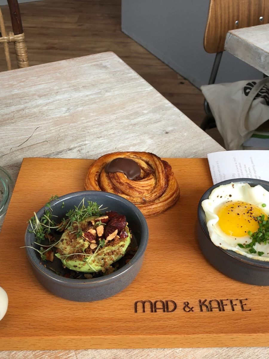Breakfast spread at Mad & Kaffe in Copenhagen with eggs, avocado, pastry, and coffee.