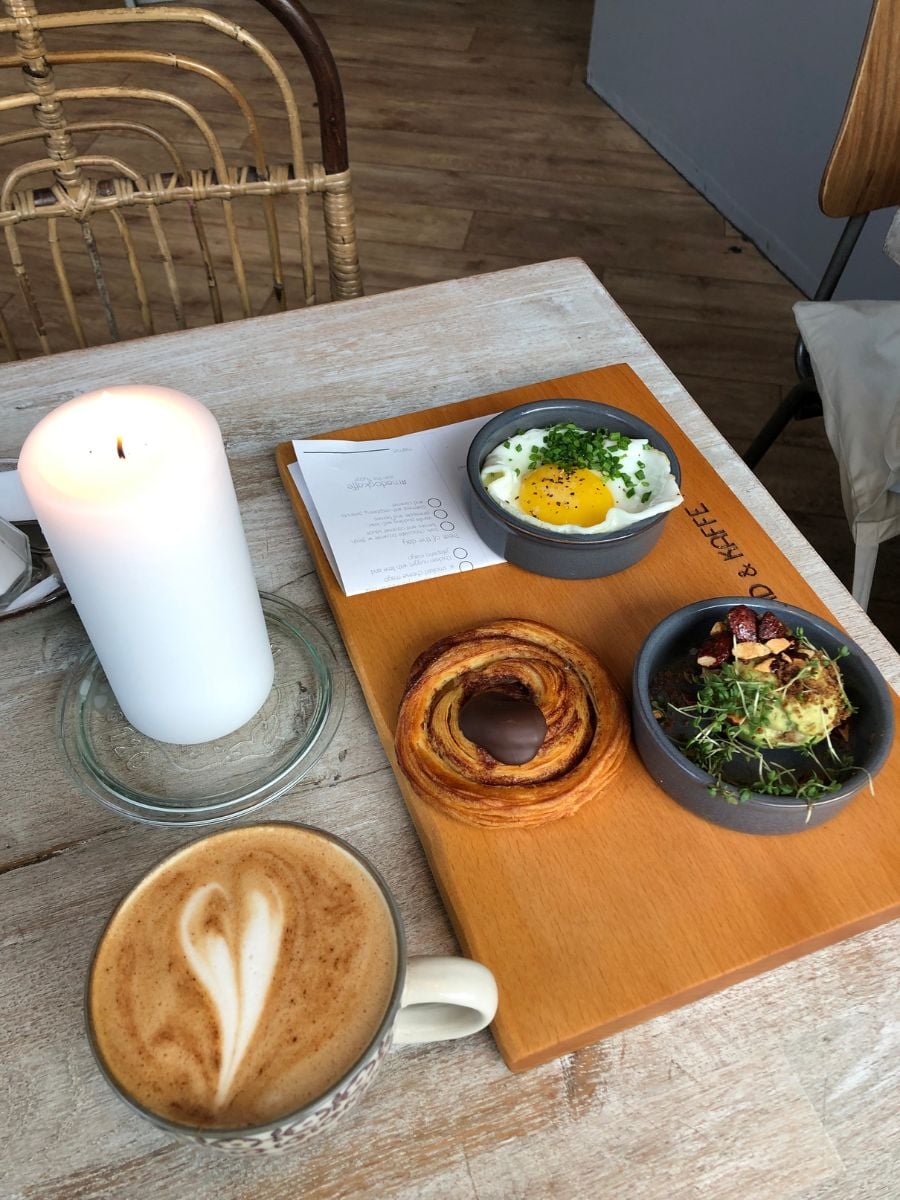 Solo breakfast at Mad & Kaffe in Copenhagen with coffee, candle, and shared plates.