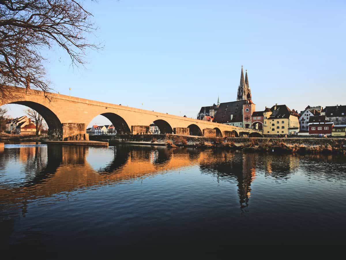 The Stone Bridge in Regensburg at sunset, reflecting on the Danube River, a landmark to explore