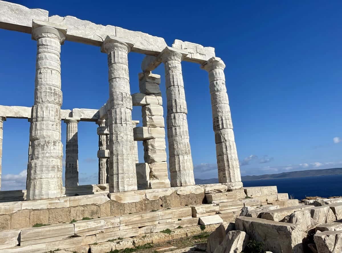 View of the Temple of Poseidon at Cape Sounion with clear blue skies, an ideal day trip destination from Athens showcasing ancient Greek architecture.