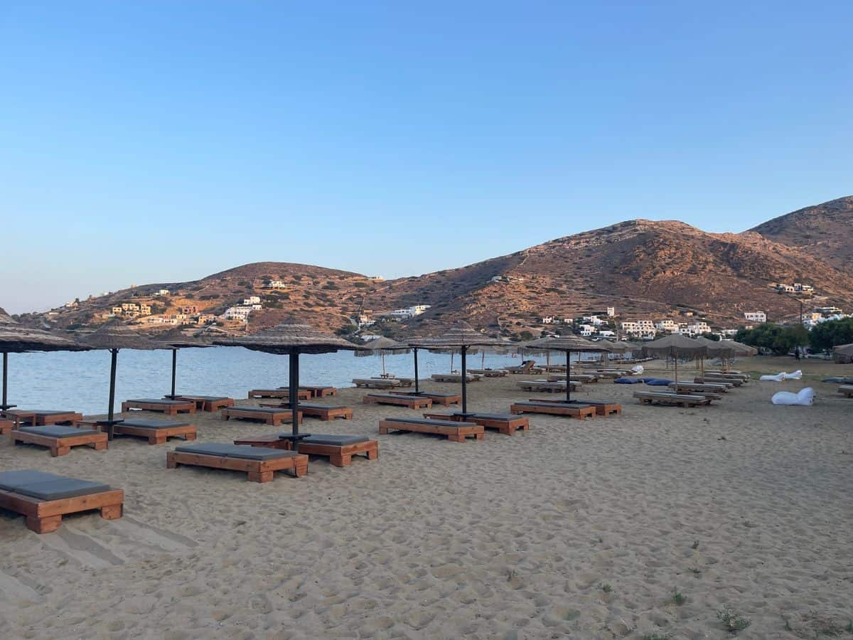A beach with empty beach chairs and a calm environment