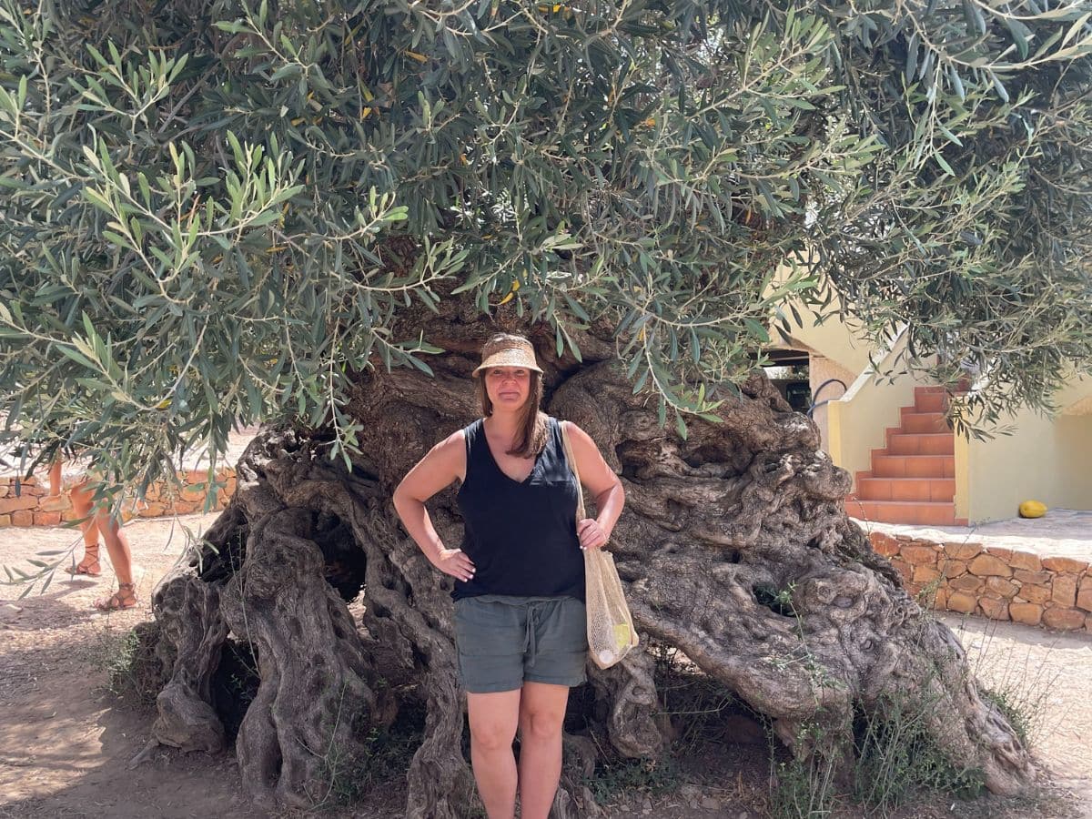 a woman at the oldest olive tree on the Island of Crete
