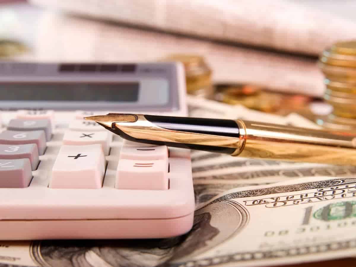 A calculator, pen and money.