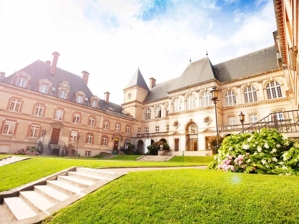 A stunning courtyard of a classical French architecture building, bathed in sunlight, which could be a highlight for someone exploring Paris on a solo trip.