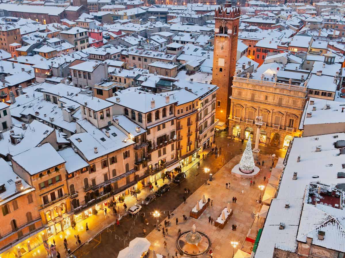 A view of Verona from above. Snow covered roofs and christmas tress in the square.