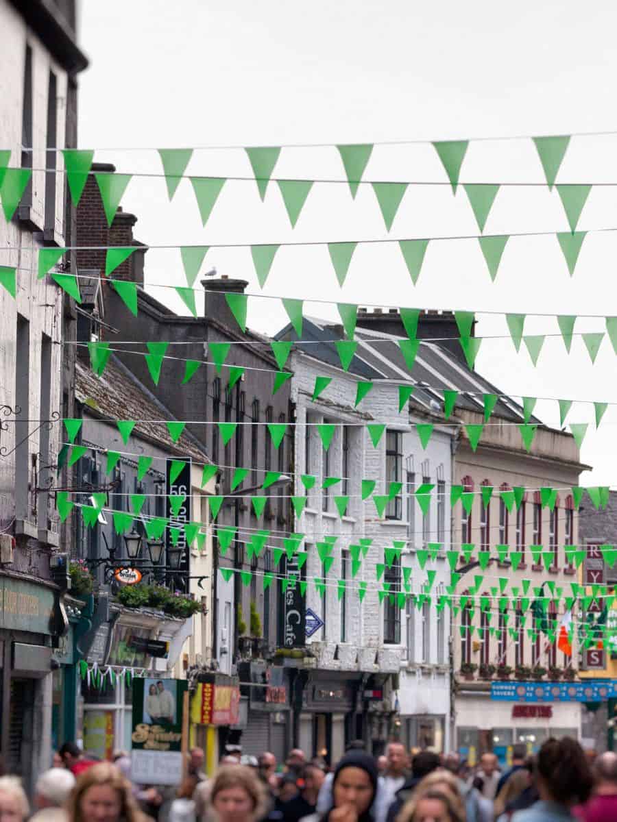 Streets of Galway with a bunch of green flags hanging above