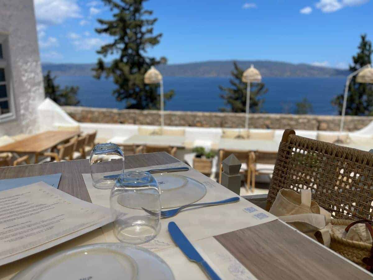 Outdoor dining table in Hydra with view of the ocean in the background