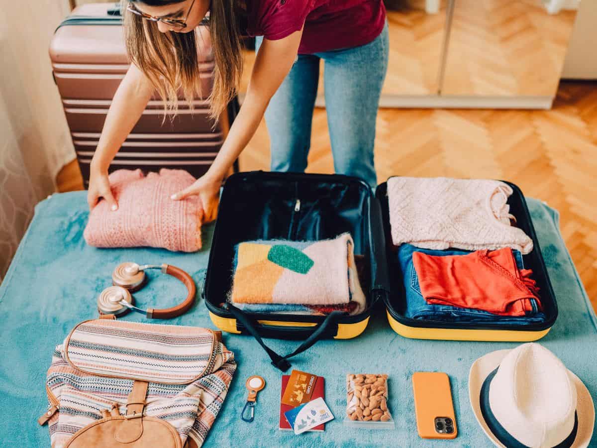 a woman packing a suitcase for a trip to Greece