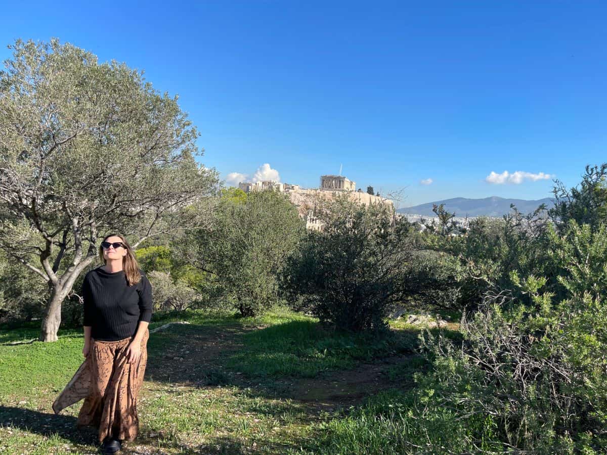 a woman living in Athens exploring the green spaces with the Acropolis in the background