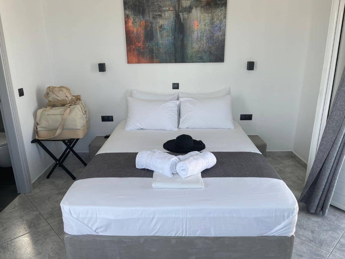 Pictures of the bed with a hat on top in folegandros
