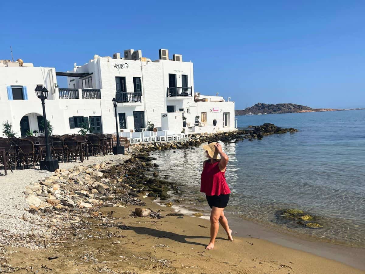 A solo woman traveling in Paros Greece at the beach.