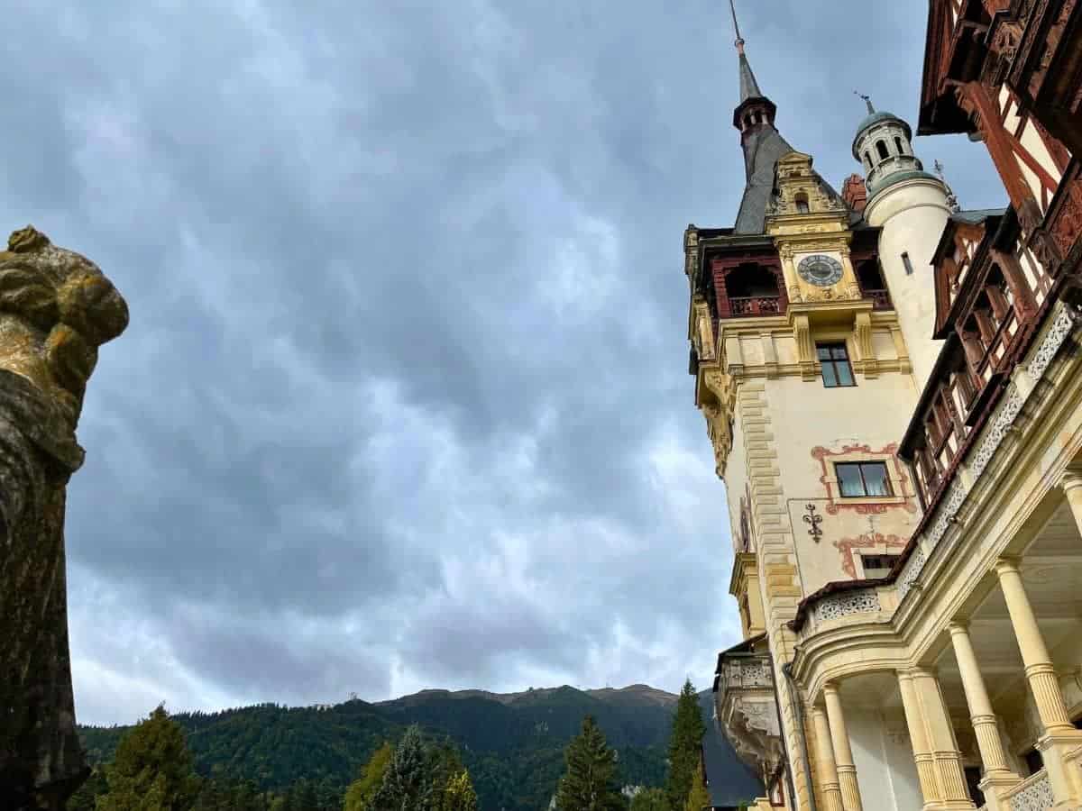 A picture of Peles castle and the mountains in the background