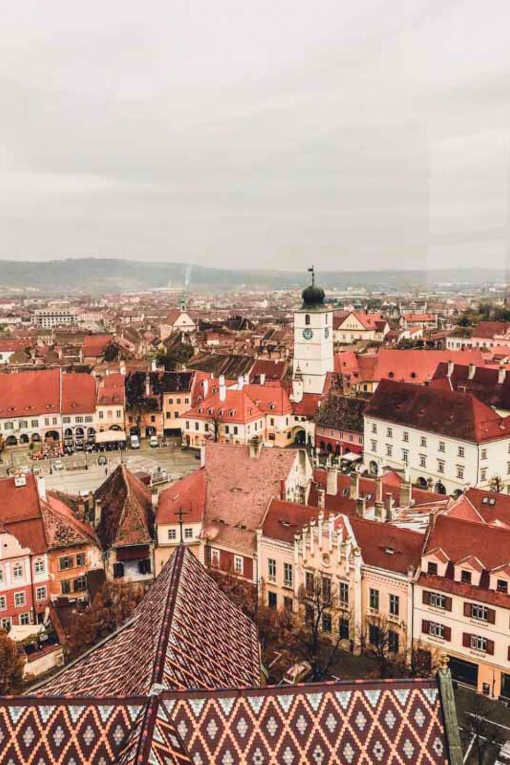 Panoramic view of Sibiu from above, with the iconic Council Tower amidst red roofs, demonstrating the picturesque beauty that answers yes to whether Sibiu is worth visiting