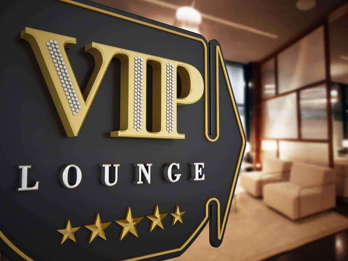 An opulent VIP Lounge sign adorned with golden letters and five stars, prominently displayed at the entrance of a luxurious airport lounge with plush seating in the softly lit background, inviting travelers to evaluate the prestige associated with Priority Pass access.