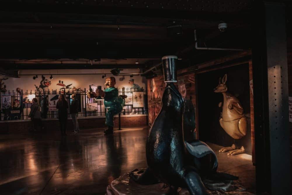 A whimsical display inside a Dublin Guinness Factory exhibition, featuring oversized, playful sculptures including a penguin with a pint on its head.
