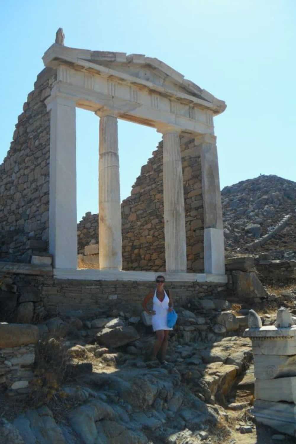 A woman in Delos Mykonos standing by an archeological site.