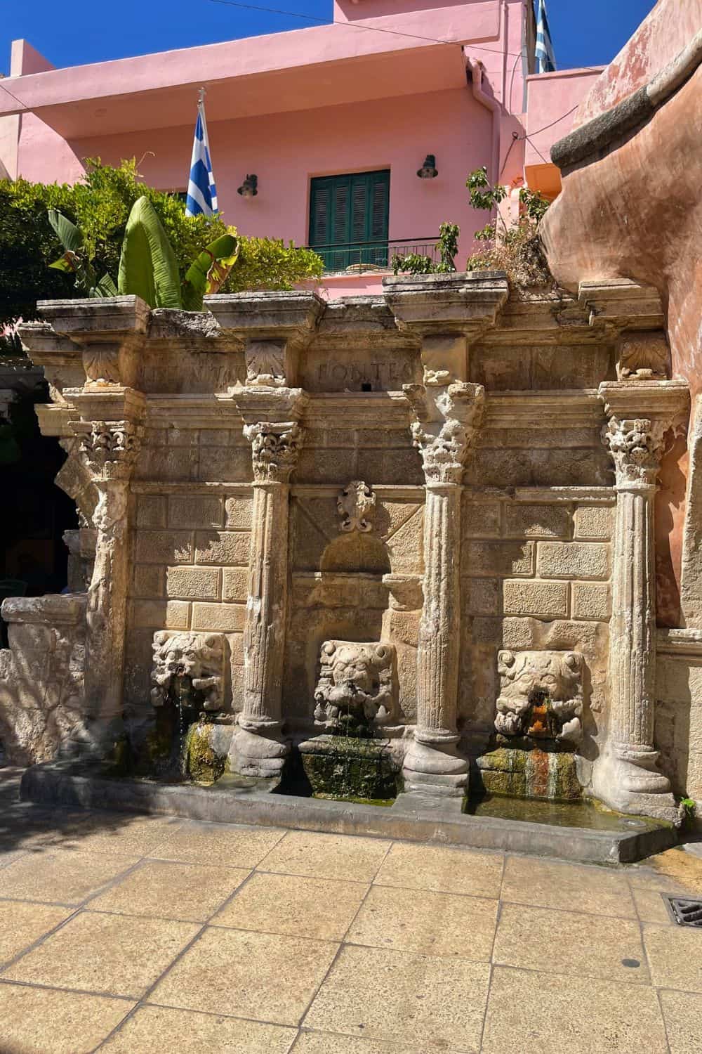 Old stone wall with fountain in Crete.