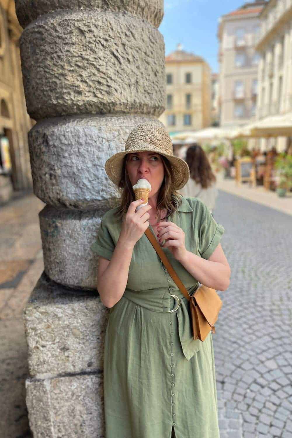 A woman alone in Verona eating ice cream