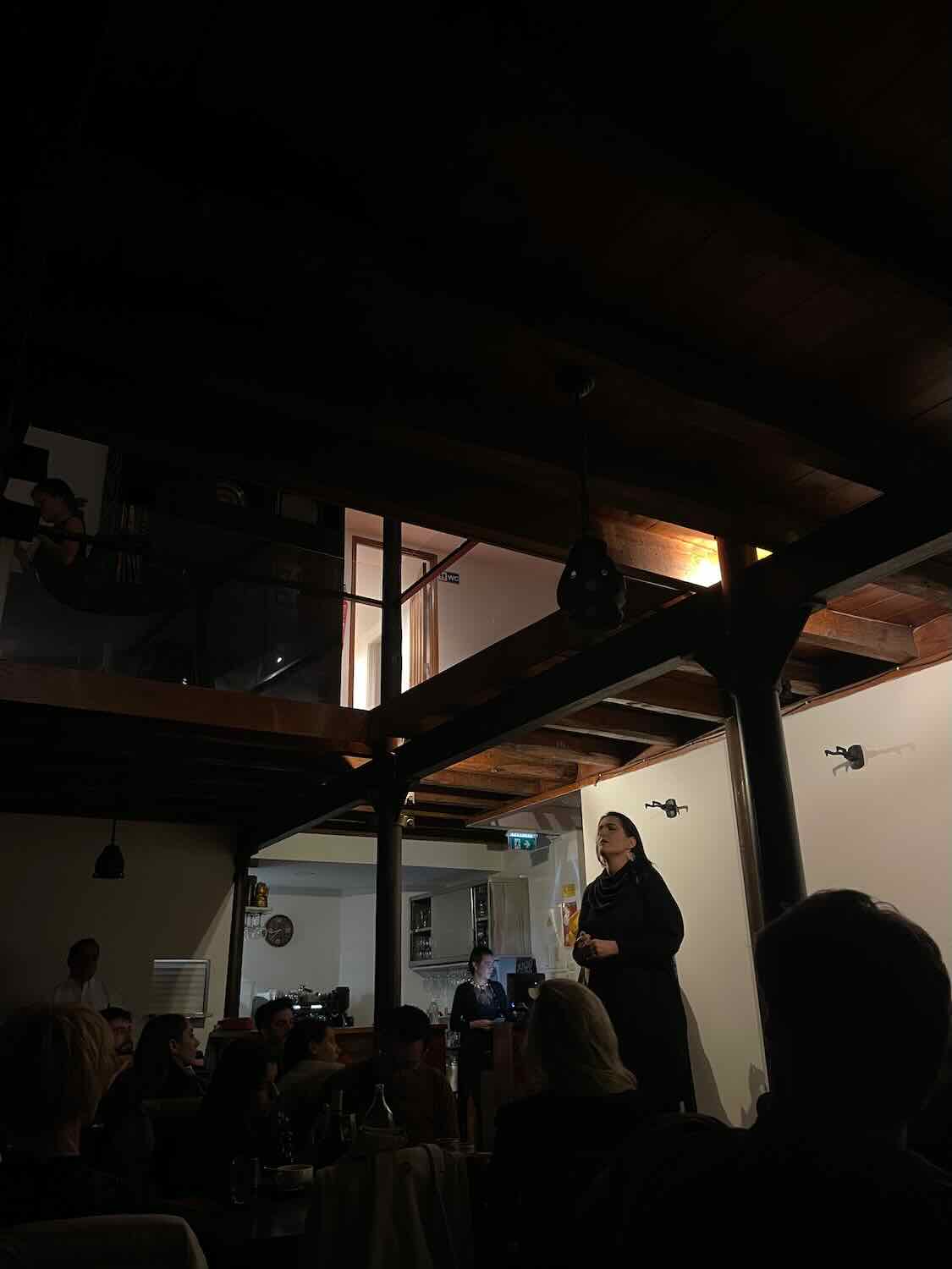 A dimly lit Lisbon Fado restaurant with an audience captivated by a Fado singer's emotional performance, exemplifying the city's rich cultural scene.