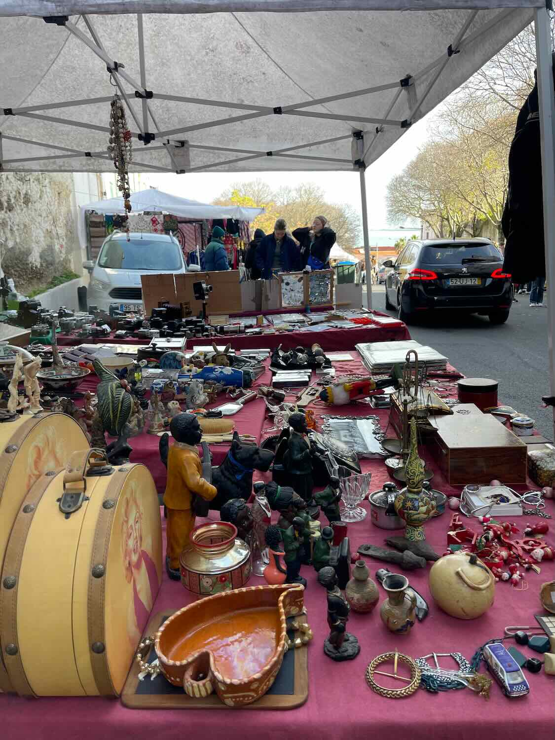 ssorted antiques and collectibles displayed at a Lisbon flea market, showcasing the city's vibrant weekend shopping and street culture.