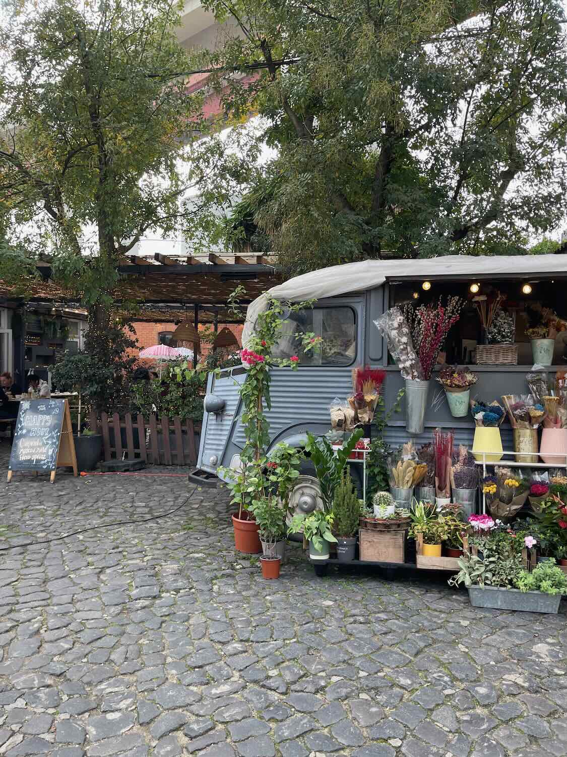 The eclectic LX Factory in Lisbon, with a vintage van repurposed into a charming flower shop, set against a backdrop of creative urban spaces