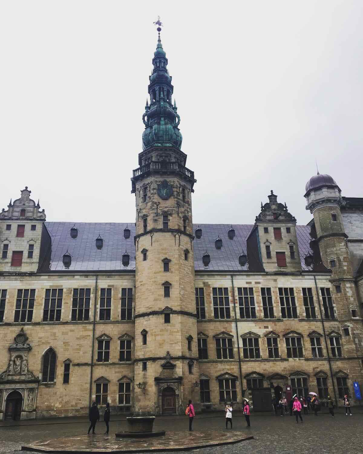 Exterior view of Kronborg Castle with its imposing Renaissance architecture against a cloudy sky.
