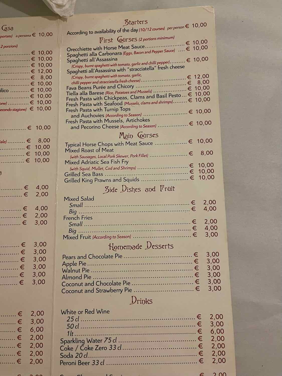 A close-up image of a restaurant menu in Bari, Italy. The menu lists various dishes including starters, first courses, main courses, side dishes and fruit, homemade desserts, and drinks. Prices are listed in Euros.