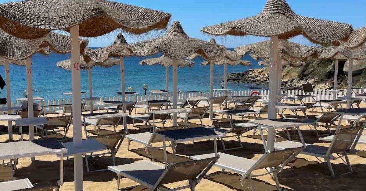 Umbrellas and sunbeds at beach club in Siracusa