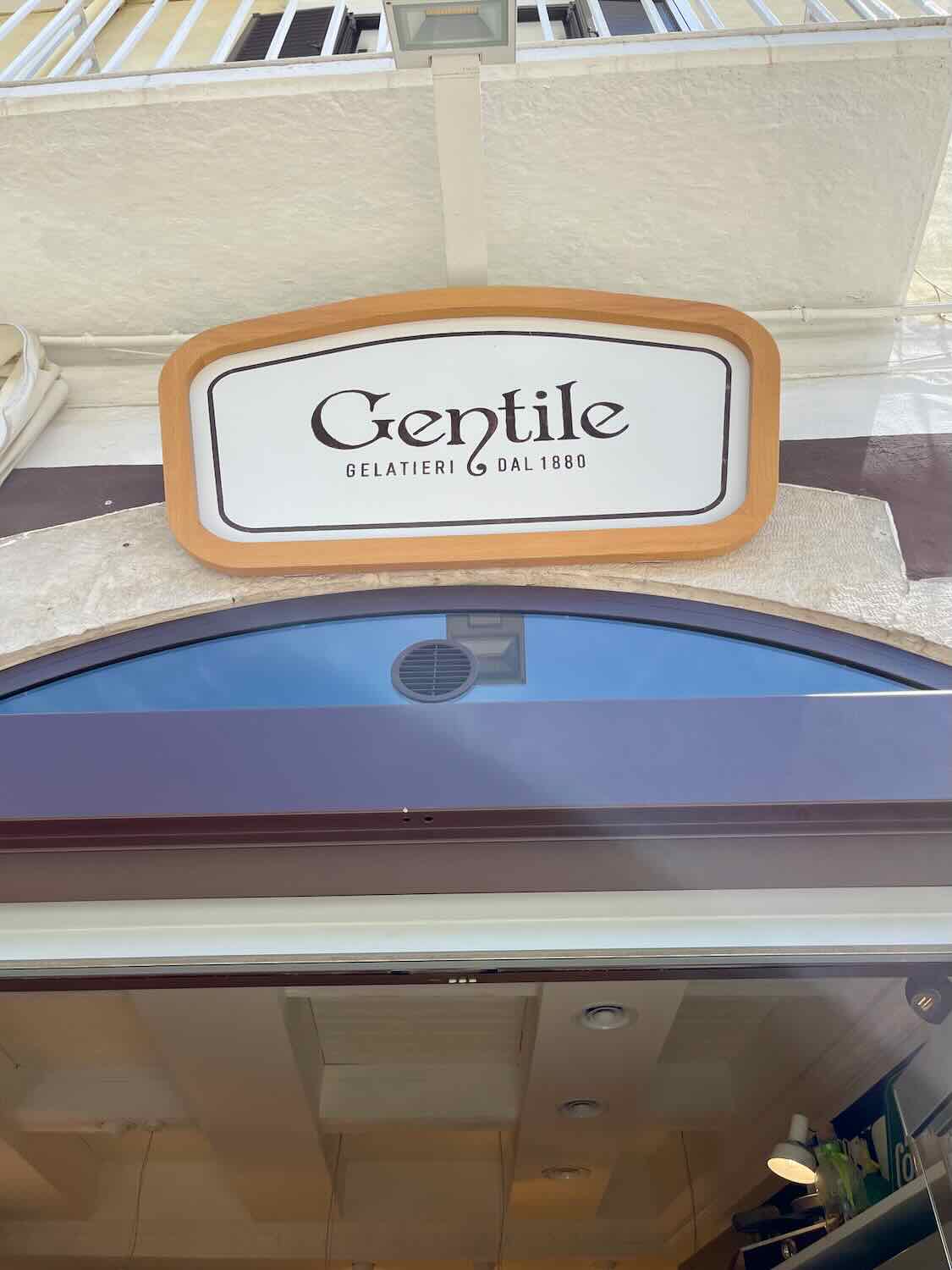 The sign for Gentile Gelateria in Bari, Italy, established in 1880. The sign is mounted above the entrance of the shop, featuring a simple and elegant design.