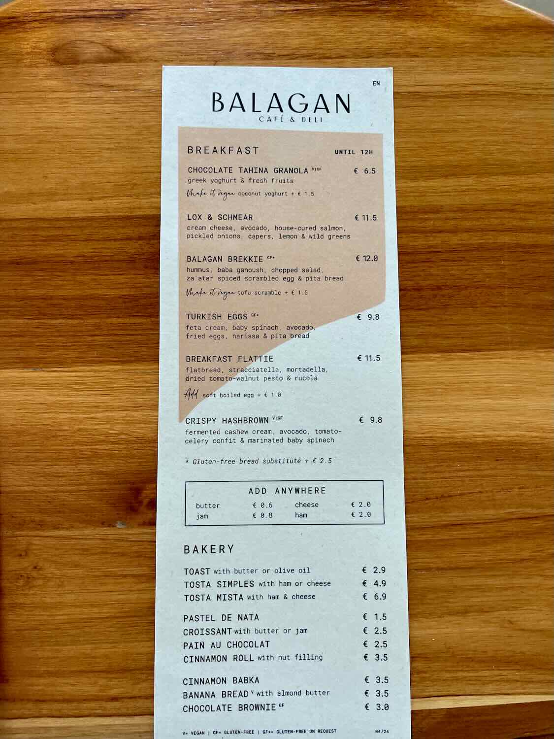 Menu from Balagan Café & Deli showing breakfast options such as Chocolate Tahina Granola, Lox & Schmear, Balagan Brekkie, Turkish Eggs, Breakfast Flattie, and Crispy Hashbrown. The menu also lists bakery items and additional options like toast, croissant, cinnamon roll, and chocolate brownie.