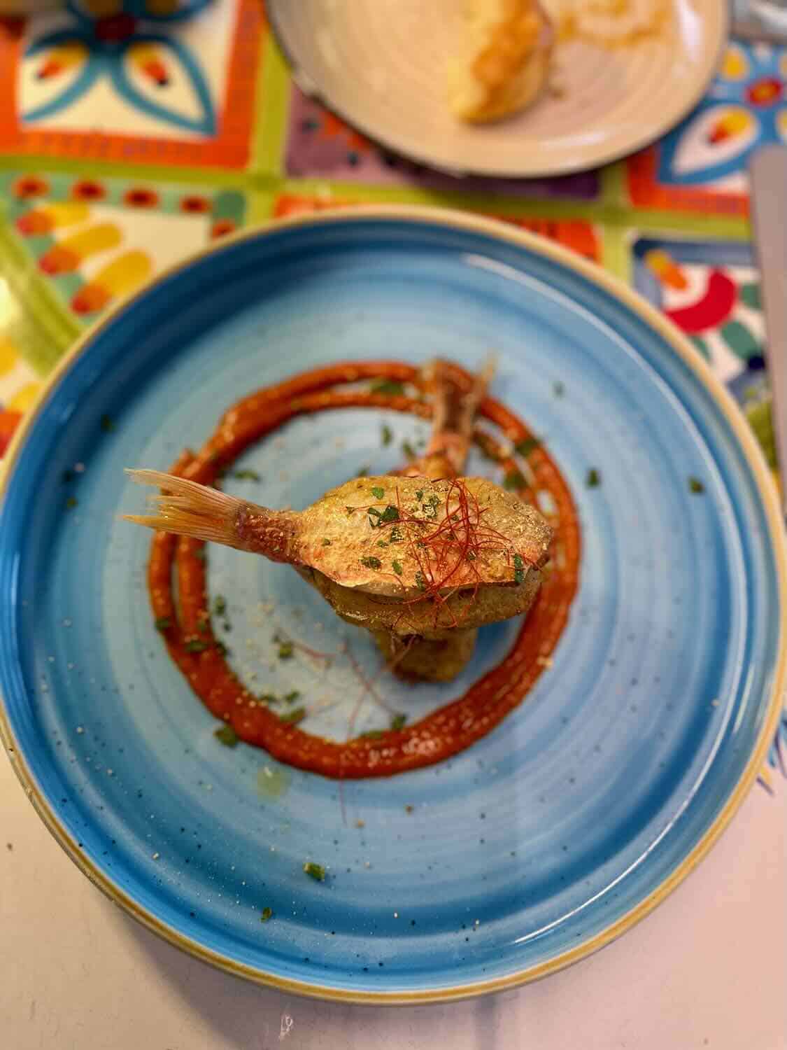 Close up picture of fish on a colorful blue plate. 