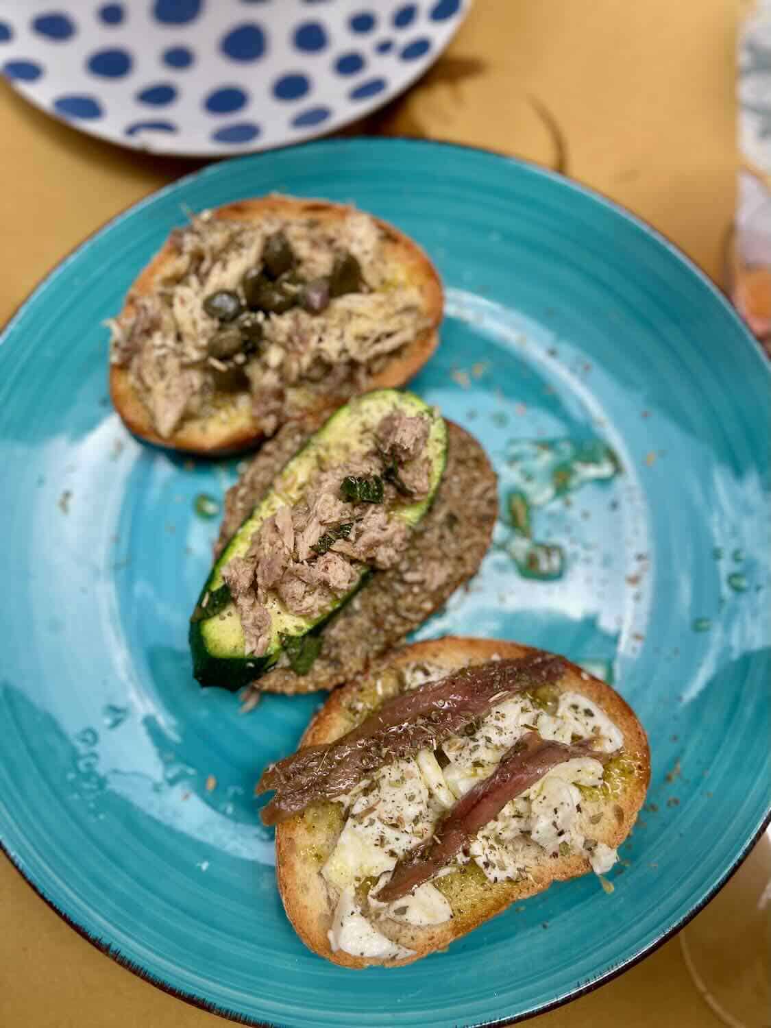 Close up of 3 pieces of bread with a variety of topping.