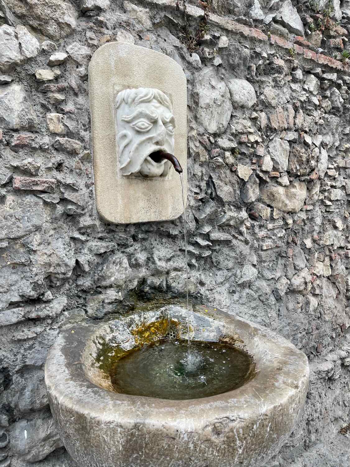 Stone fountain on the wall in Taormina