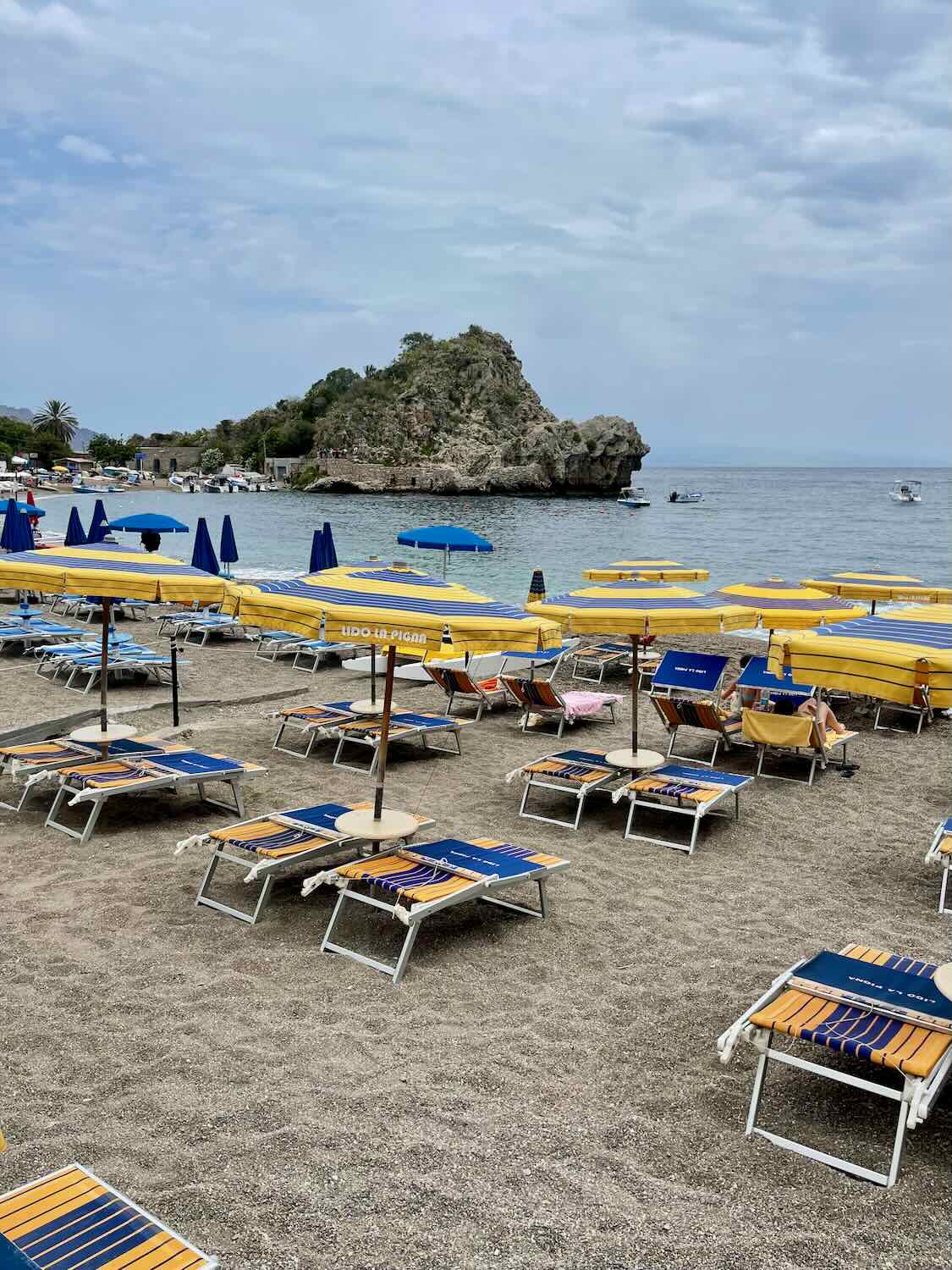 View of the beach with rows of the beach chairs and umbrellas. 