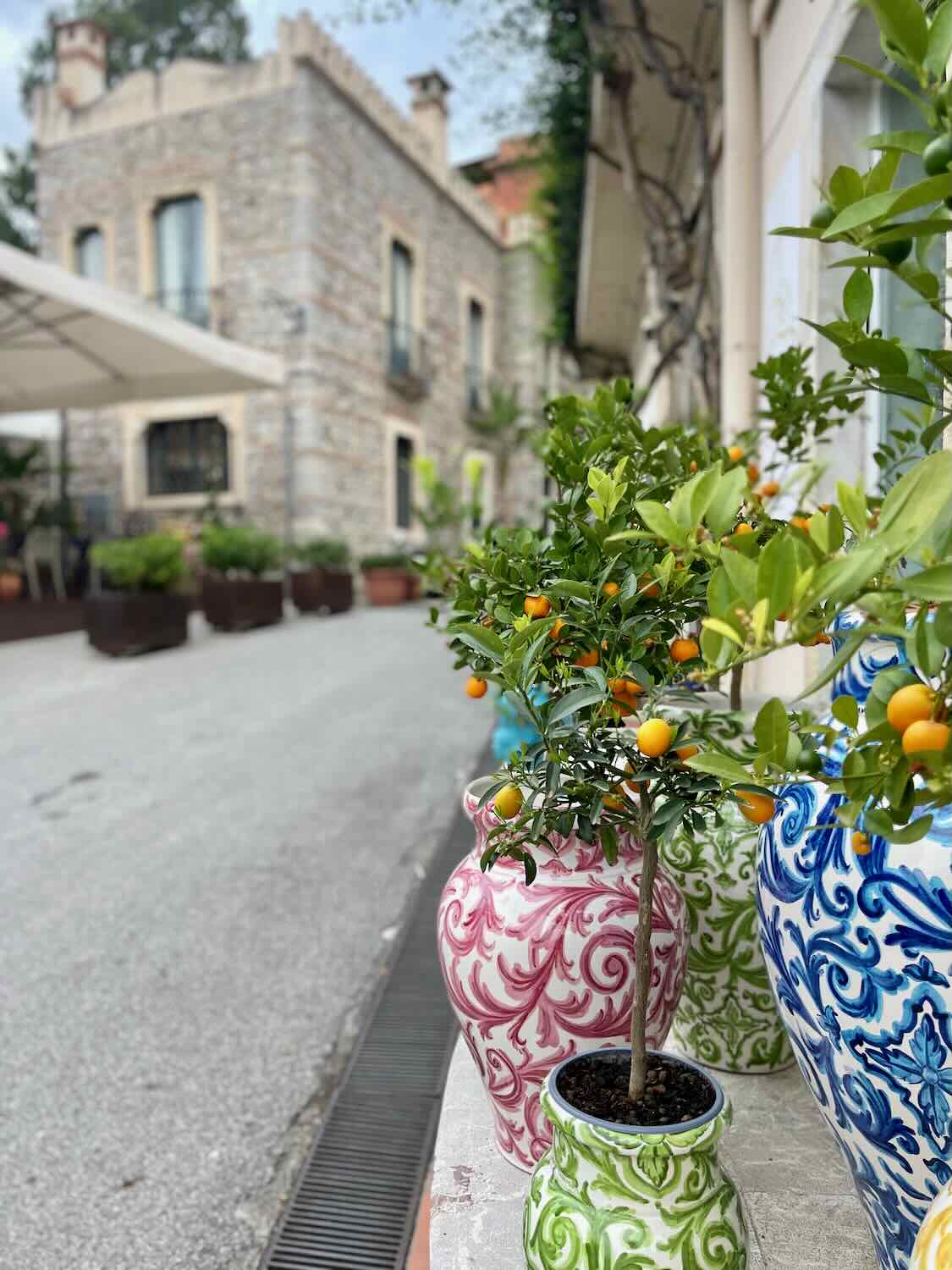 View of the streets in Taormina with a close up of potted plants. 