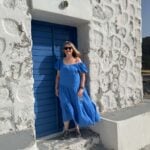 A woman in a blue dress smiling on a small group trip with A Solo Woman Traveling.