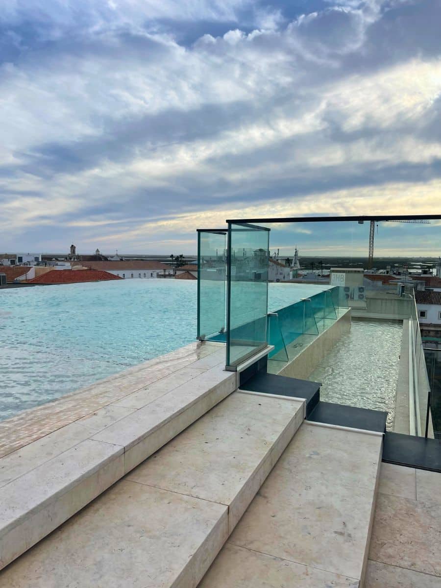 Rooftop infinity pool with panoramic views of Faro&rsquo;s old town and the coast.