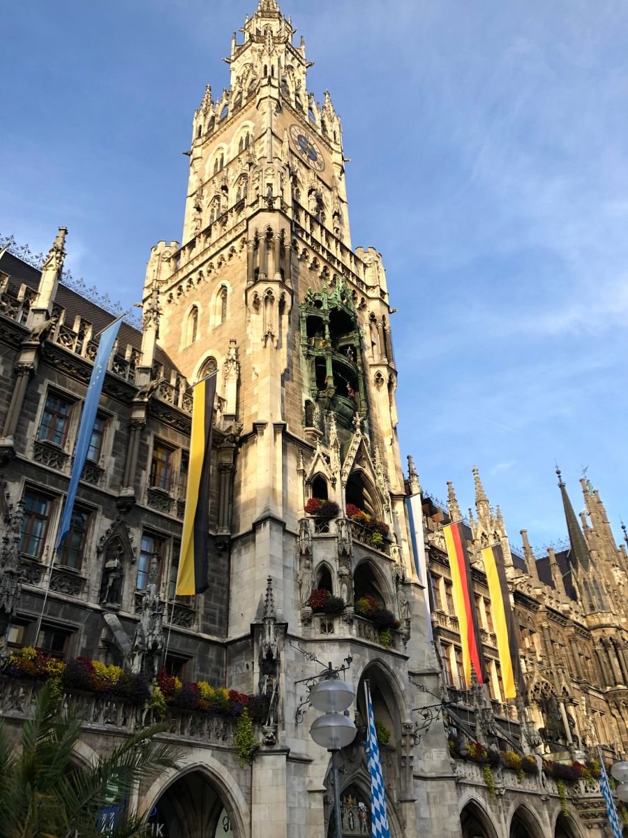 The Neues Rathaus (New Town Hall) tower in Munich’s Marienplatz, decorated with flags and flower boxes.