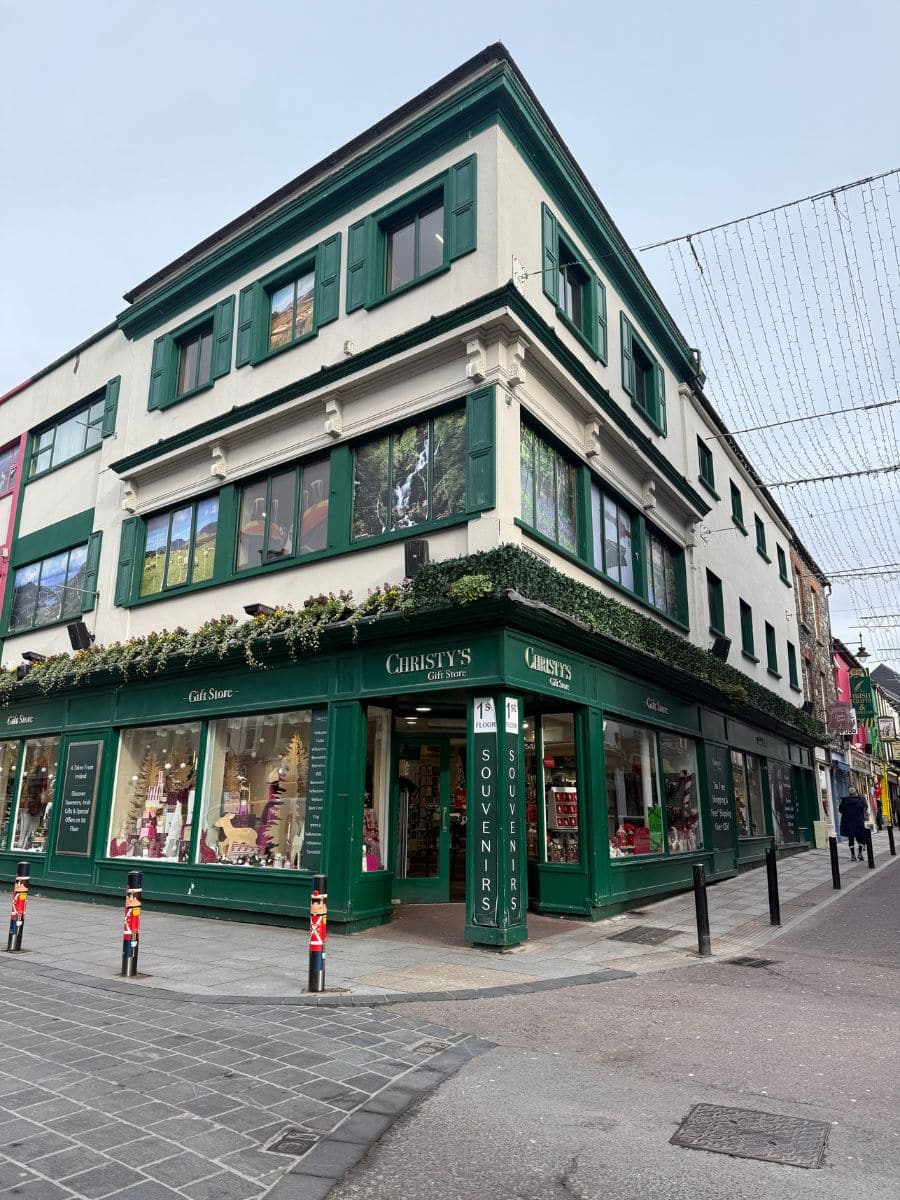 Exterior of Christy&rsquo;s Gift Store in Killarney, a green-trimmed corner shop known for Irish souvenirs.
