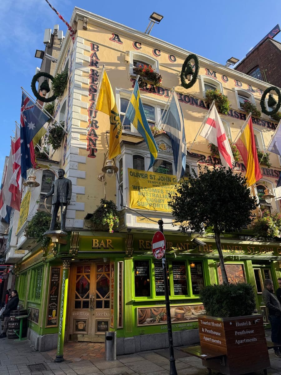 Colorful exterior of a traditional Irish pub in Temple Bar, decorated with international flags and bright green trim.