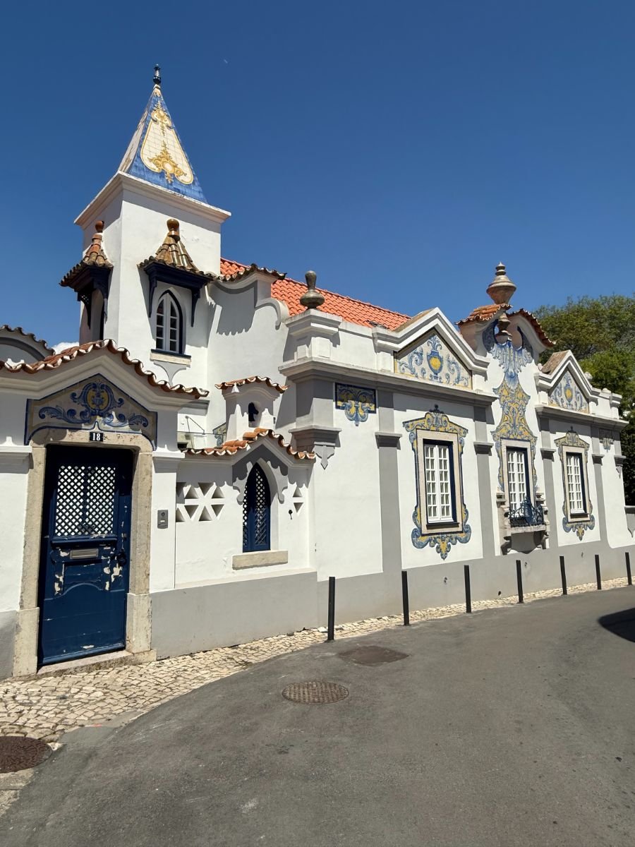 Traditional Portuguese house in Cascais with decorative azulejo tiles, white façade, and terracotta roof under a clear blue sky