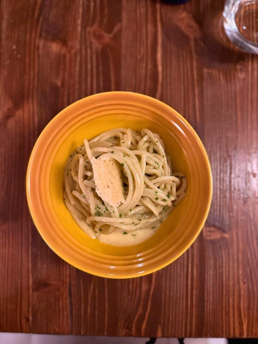 Bowl of pasta served on a wooden table at a restaurant in Venice.