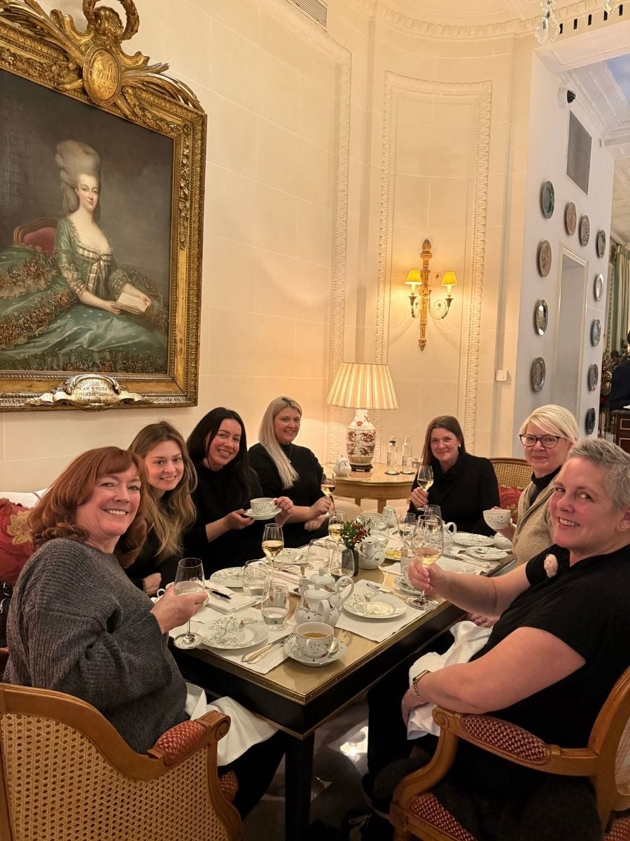 Group of women enjoying tea and wine together in a luxury Paris hotel lounge during girls&rsquo; trip