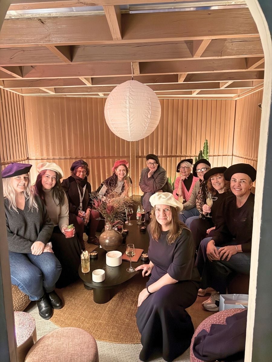 Group of women enjoying drinks together in a cozy indoor lounge during a girls&rsquo; trip in Paris.
